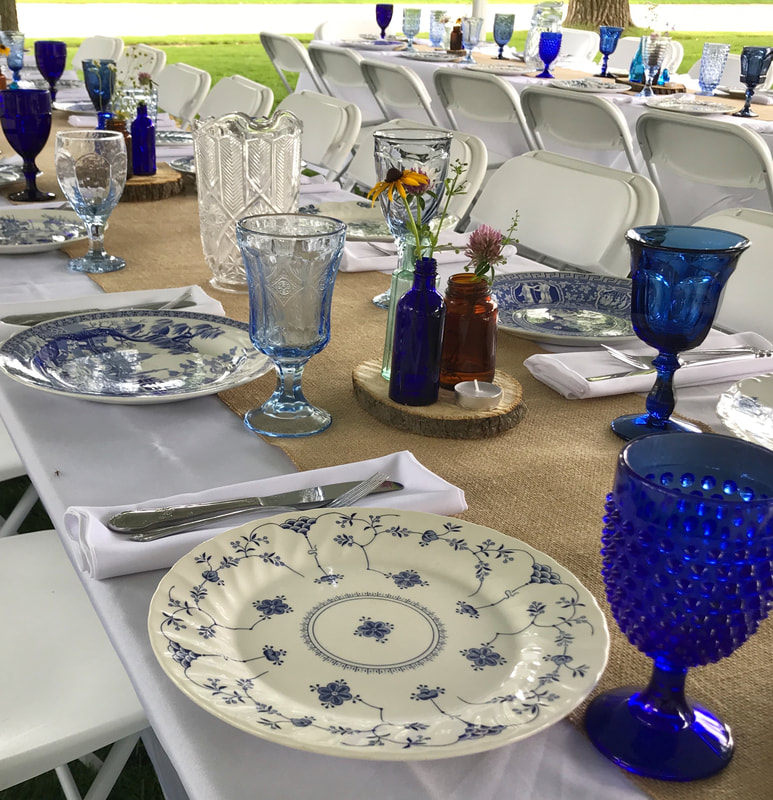 Backyard wedding with a table setting of our  Blue and white dinnerware rentals and our mix of blue water goblet rentals in Crystal Lake IL.