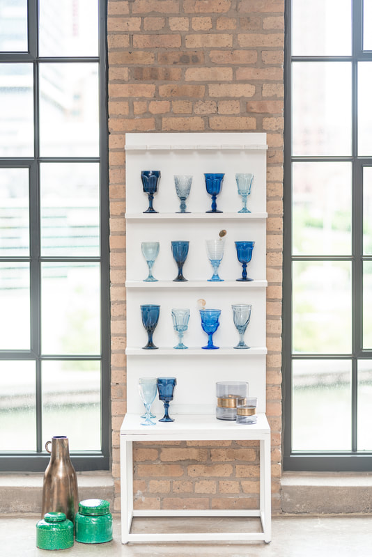 Light blue and navy blue wine glass rentals on a wall in Chicago IL 