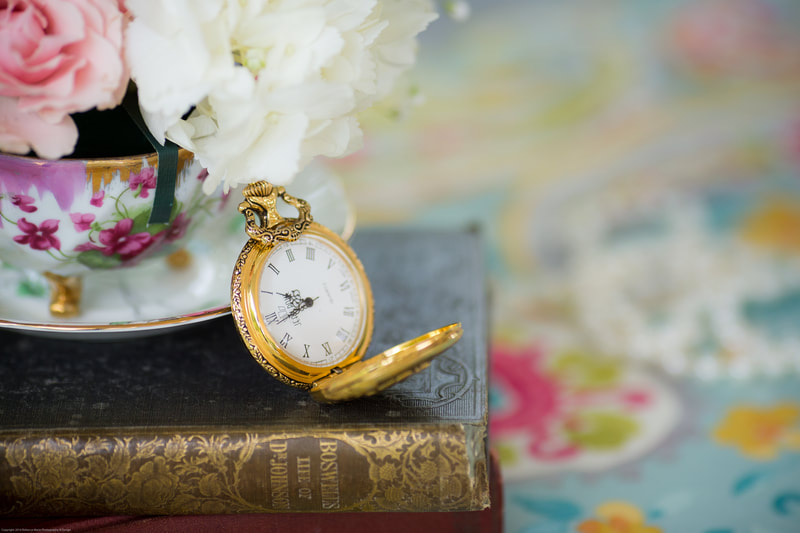 Tea party rentals for centerpieces. Pocket watches, book, teacups and saucers.