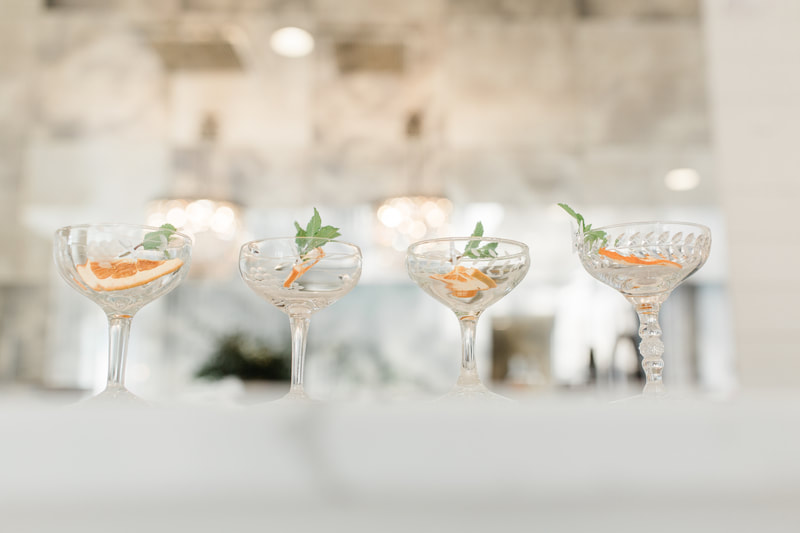 Cocktail coupe style glasses with a mint cocktail inside at the bar at Providence Vineyard wedding venue