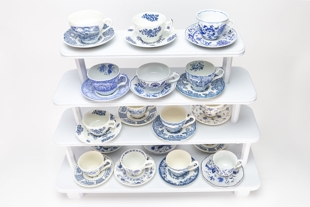 Blue and white dishes, teacups and saucers on white wooden stand