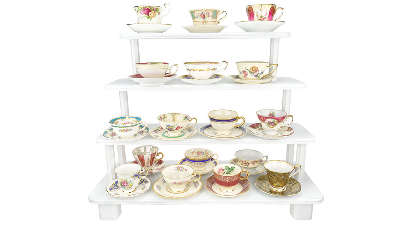 Vintage mismatched Bold and Beautiful teacups and saucers on a white wooden four-tiered stand