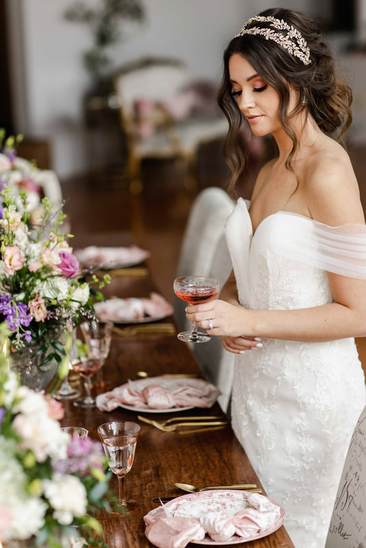 Bride holding a champagne glass in front of pink dishware rentals in Elgin IL