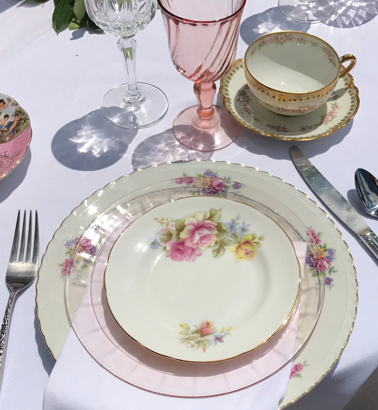 Vintage china plate rentals stacked on top of a pink glass plate at a bridal shower
