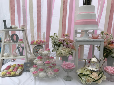 Sweet table decorated with white props and pops of pink