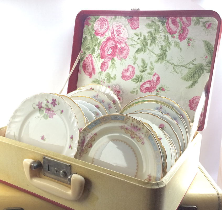 Yellow suitcase with mismatched dessert Elegant Floral plates