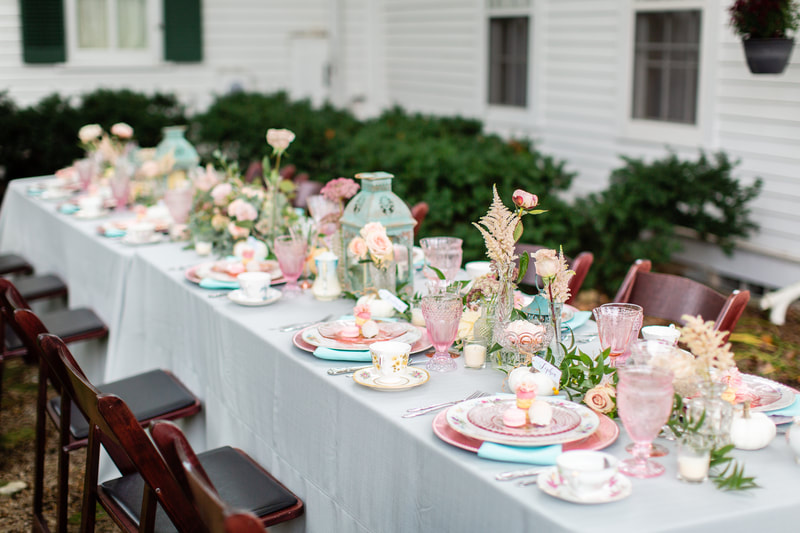 Long table in front of a house with pink dish and pink glass rentals in Wisconsin