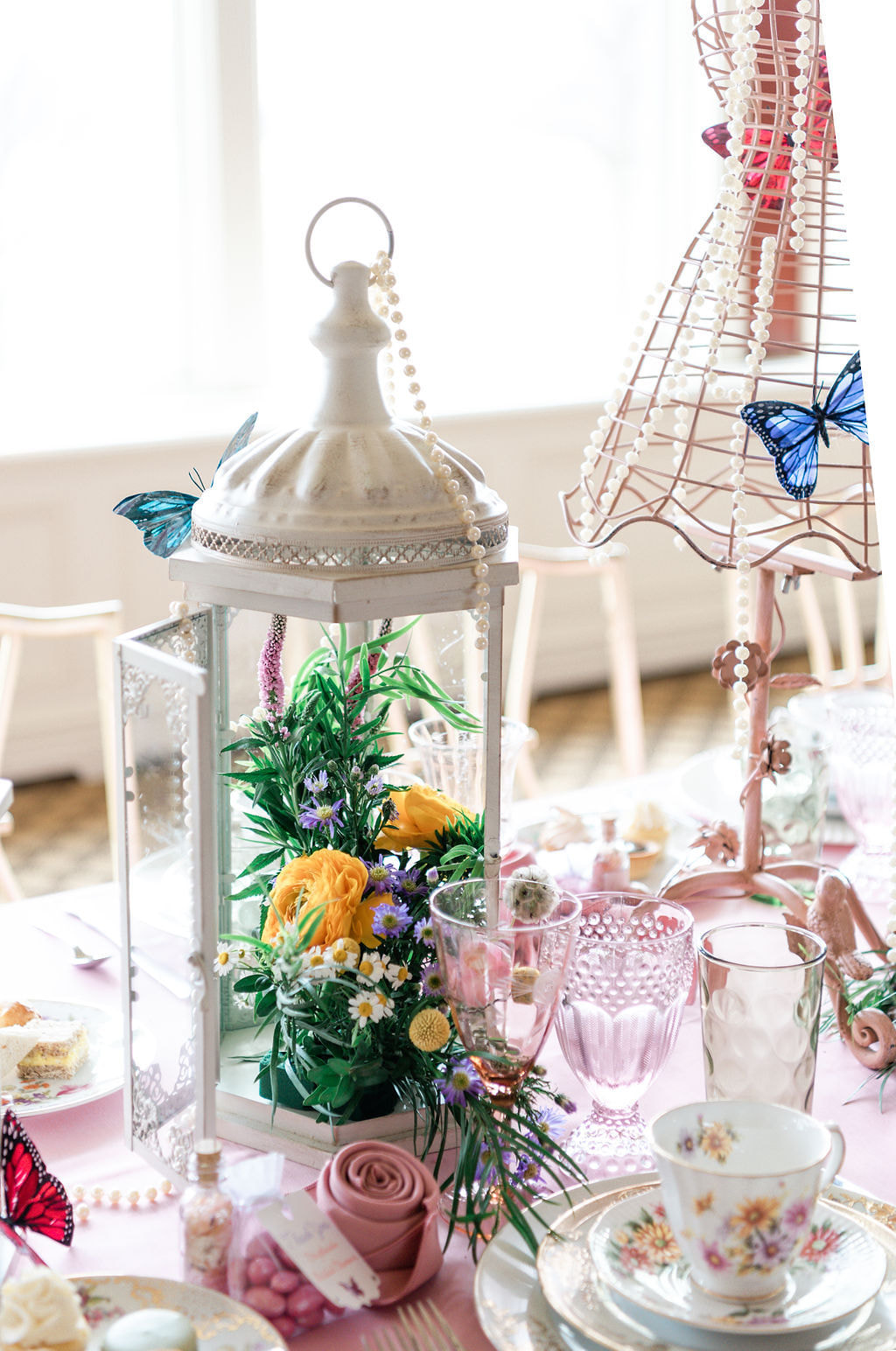 teacups and saucer  with pink goblets and decorated lantern