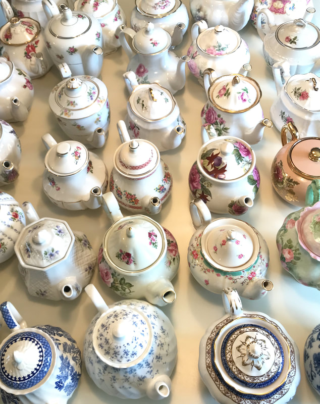 Vintage teapots used as flower vessels for a wedding centerpiece