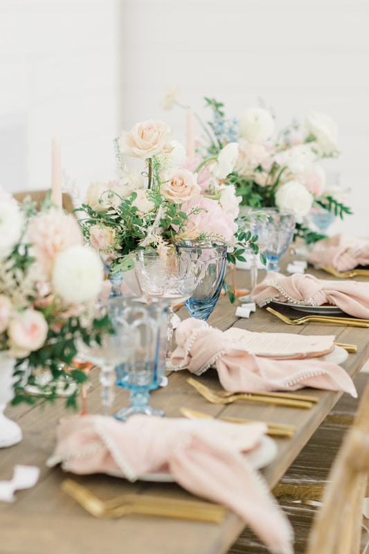 Pink and blue glassware rental on a farm table at providence vineyard wedding venue