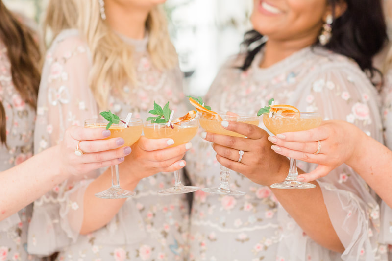 Bridesmaids holding a coupe style wedding cocktail at Providence Vineyard venue