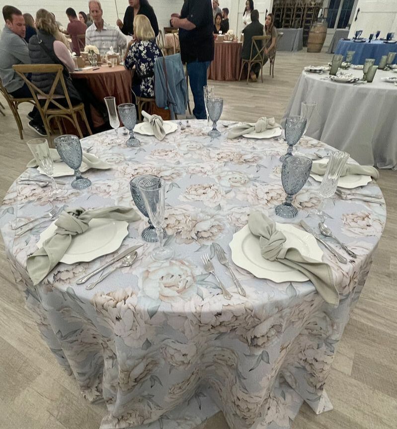 Sample reception table featuring dusty blue goblets, Water Lily plates, mismatched flatware, sage napkins and Lorelei table linen.