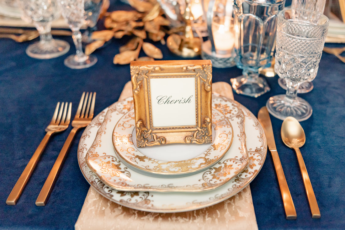 Glorious Gold dinnerware with brushed gold flatware and Bella goblet with light blue goblets. 